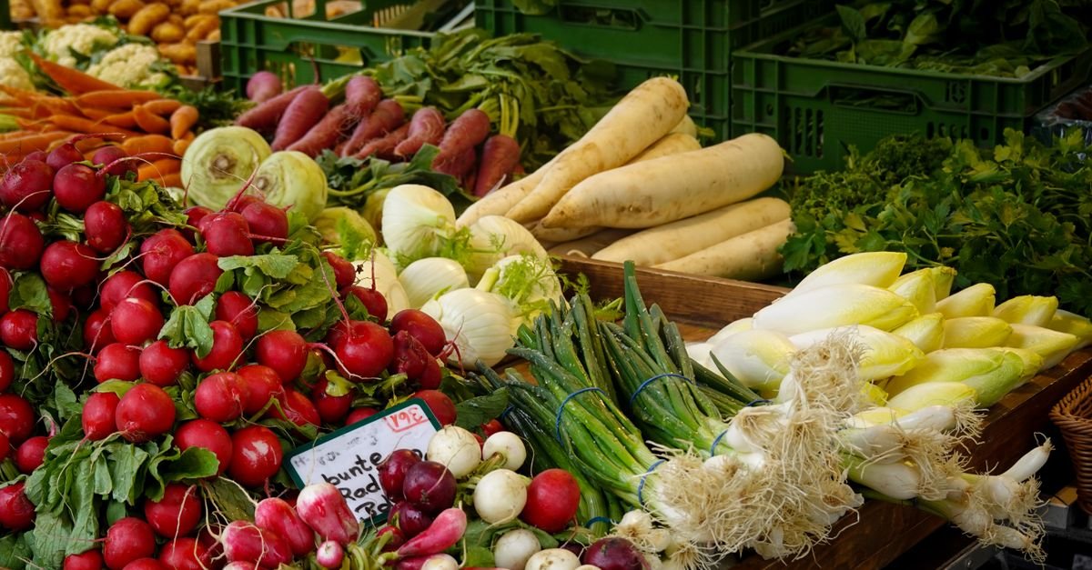 A colourful farmers' market stall piled with fresh seasonal vegetables and farm-to-table produce